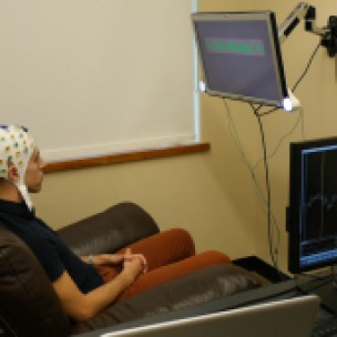 Participant wearing an electroencephalography (EEG) cap that records brain activity and sends a response to a second participant over the Internet. (University of Washington)
